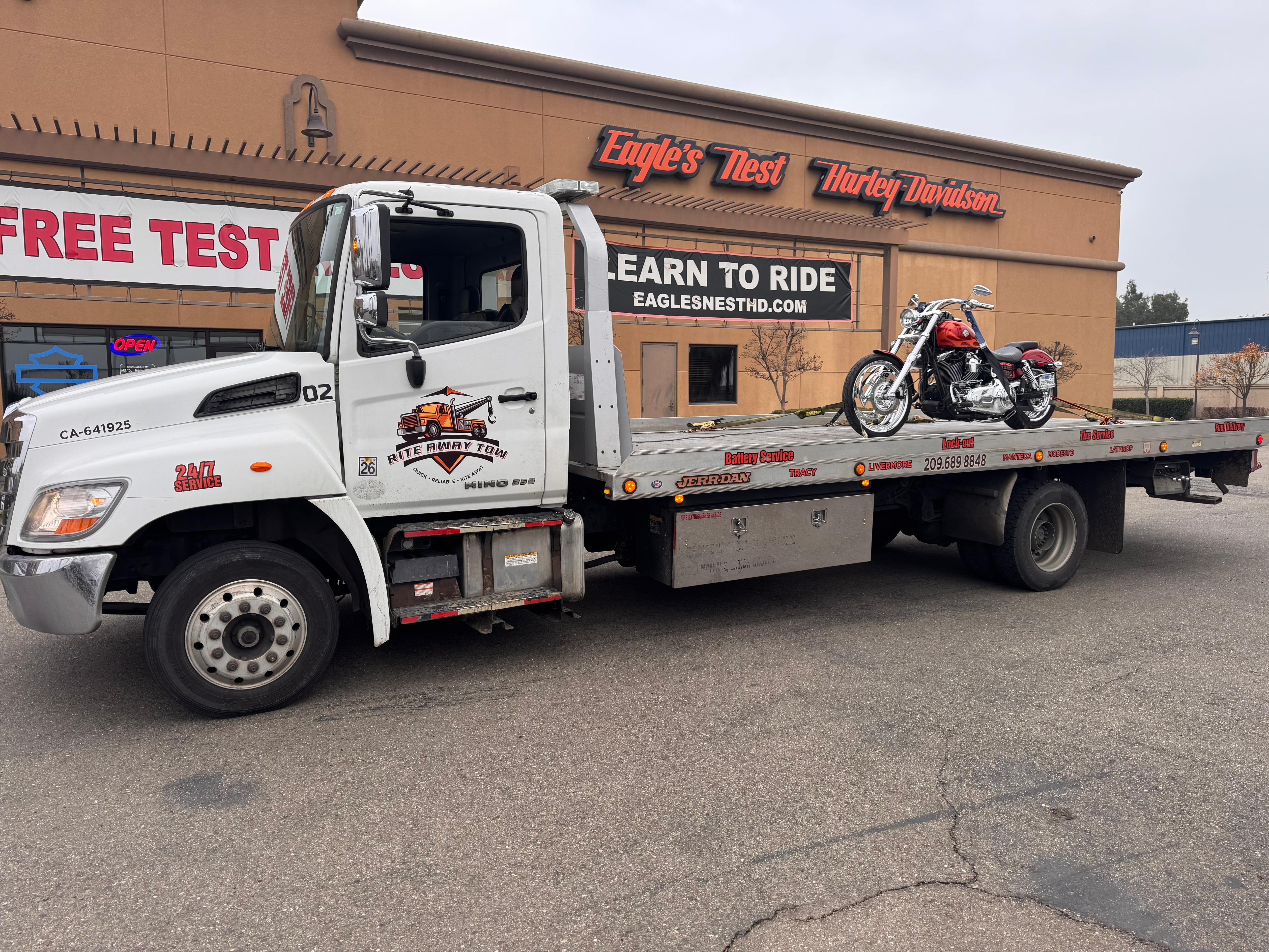 Harley-Davidson motorcycle strapped down on a Rite Away Tow flatbed at Eagle's Nest HD in Tracy