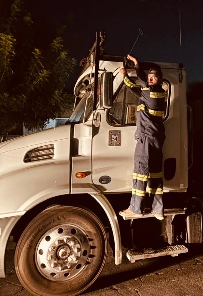 Rite Away Tow technician unlocking a class-8 semi-truck cab at night