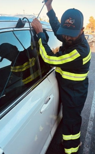 Rite Away Tow technician using a non-destructive slim-jim tool on a passenger car