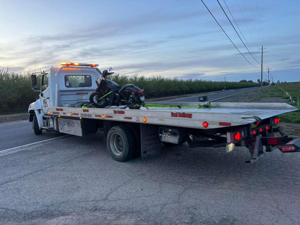 Flatbed tow truck loading a motorcycle for transport in Tracy, CA